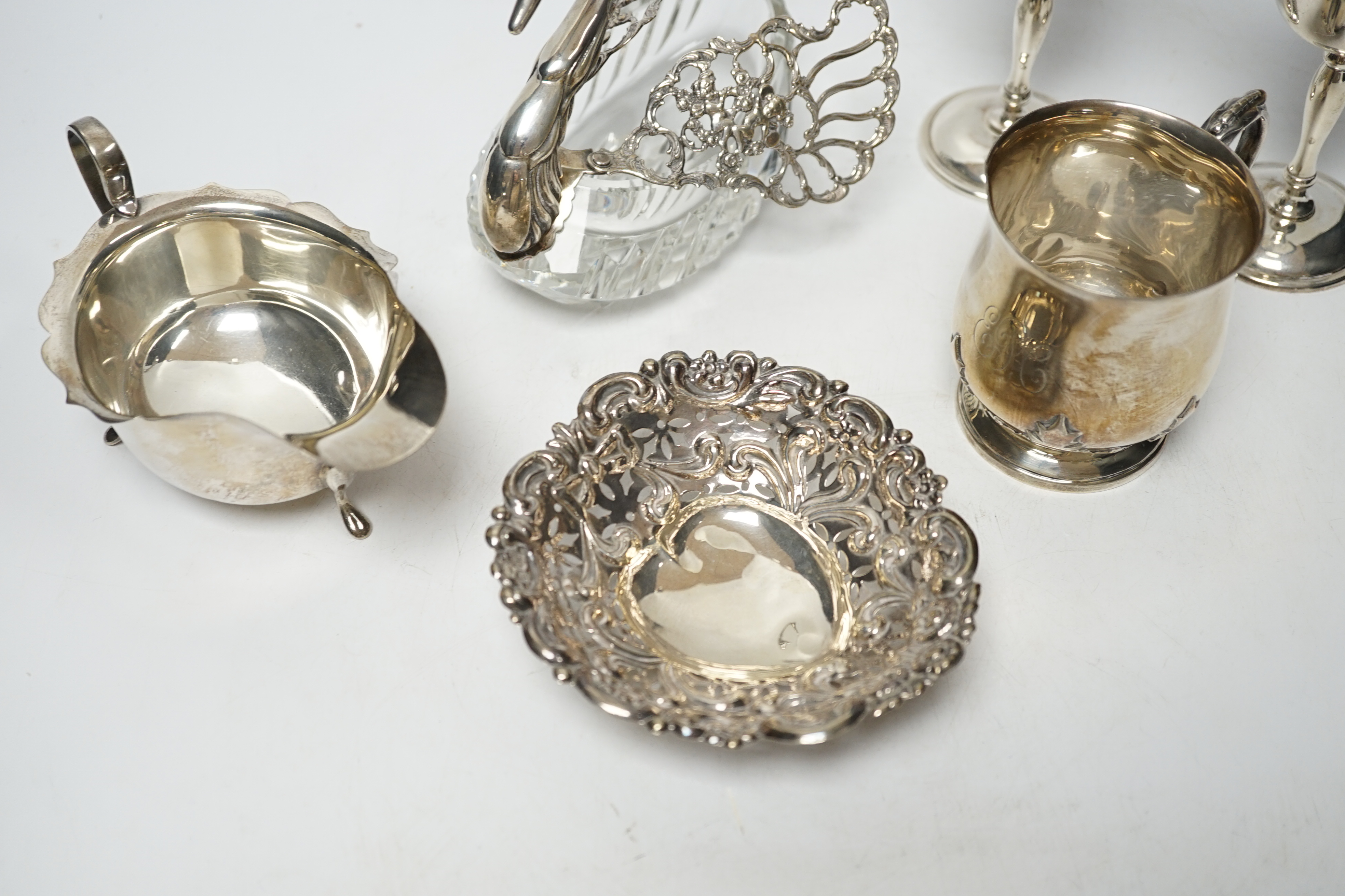 A George V silver christening mug, with card cut decoration, Adie Bros. Birmingham, 1903, height 81mm, a silver sauceboat, a dish, a pair of modern silver goblets and a 1970's silver mounted glass 'swan' bonbon dish.